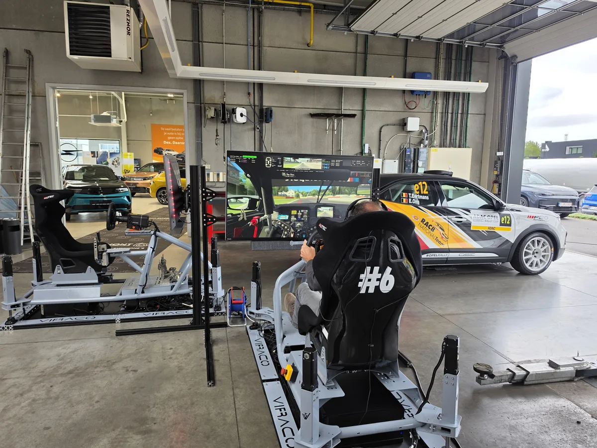 Twee Viraco motion simulatoren opgesteld in een garage tijdens een klantenevent, met een rijder achter het stuur